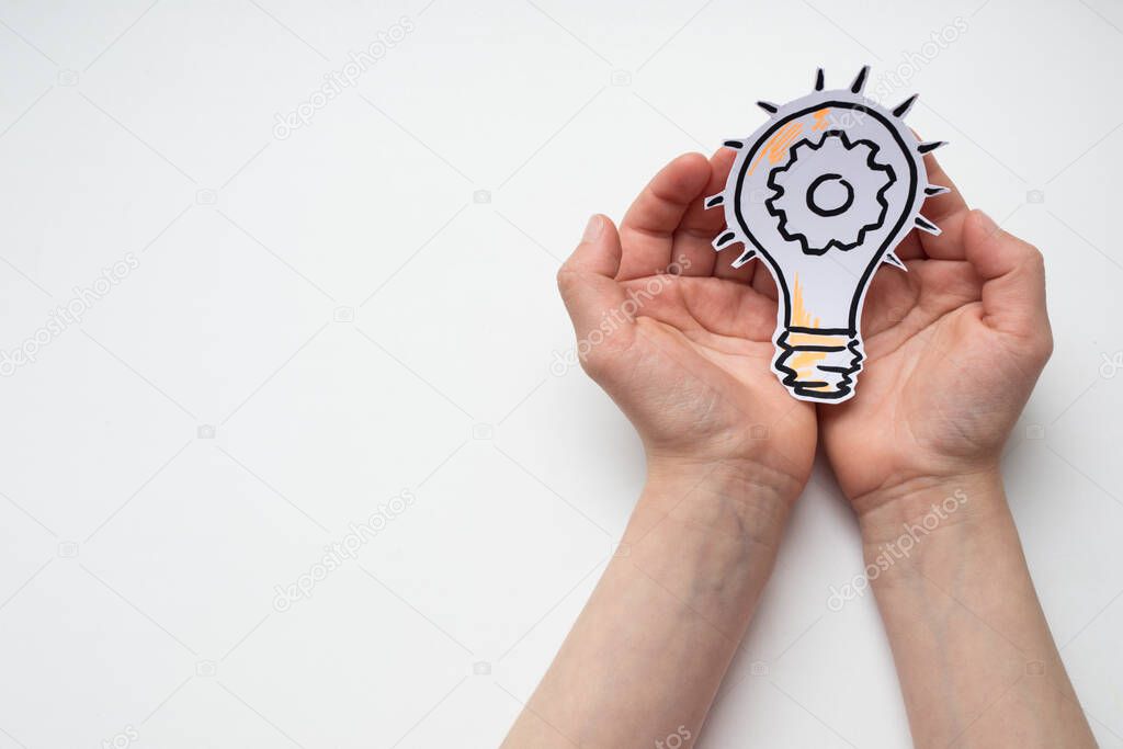 Drawn light bulb in hands on a white background