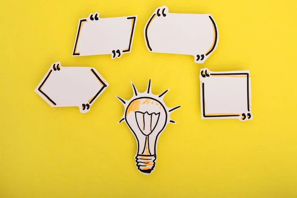 Paper speech bubbles and bulb icon on the yellow — Stock Photo, Image