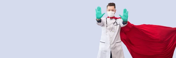 A doctor in a costume of a super hero stands on defense against a viral pandemic