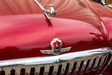 Samara, Rusya - 19 Mayıs 2018: Şahlanan geyik - maskot ve retro bir araba Volga Gaz-21 araç kaporta logosu