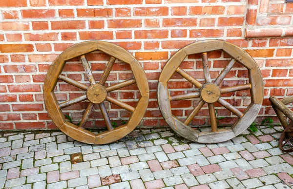 砖墙附近的旧木制马车车轮 — 图库照片