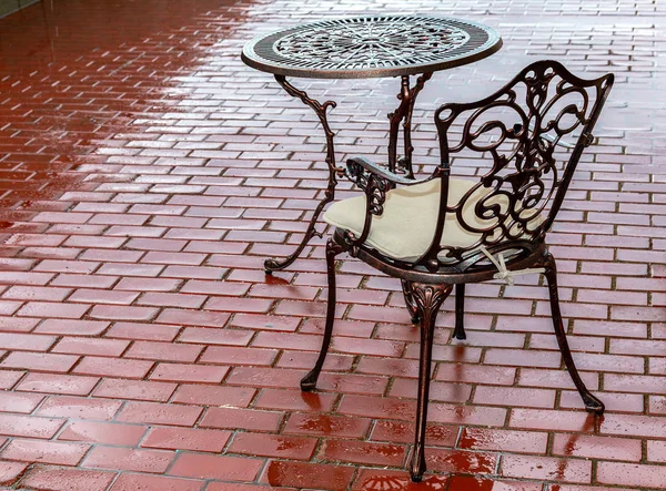 雨后户外咖啡馆的镂空金属桌子和椅子 — 图库照片