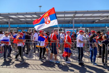 Samara, Rusya - 17 Haziran 2018: Neşeli ve dekore edilmiş futbol taraftarları ile 2018 Dünya Kupası sırasında Samara Arena Stadı yanındaki Sırbistan bayrağı