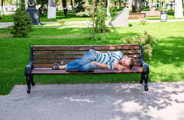 Samara, Rusya Federasyonu - 15 Eylül 2018: Evsiz adam şehir Park ahşap bank üzerinde uyuyor