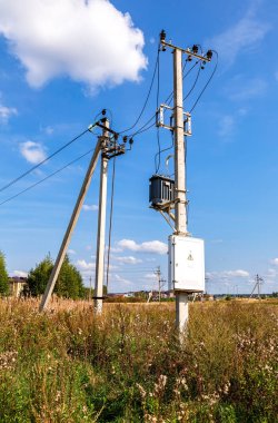 Trafo yüksek güç istasyonunun mavi gökyüzüne karşı ayağı üzerinde