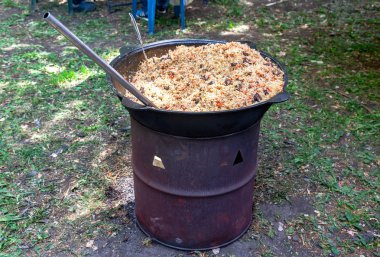 Açık havada büyük bir kazan içinde geleneksel özbek pilav pişirme