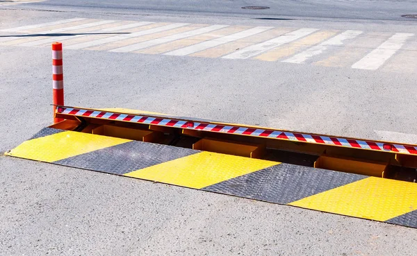 Road barrier with yellow and black striped caution pattern, road fence construction at the city street