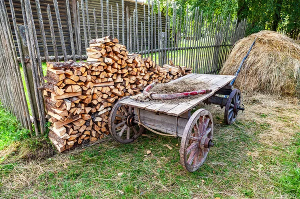 カントリー ライフ 積み上げの薪と夏の干し草のスタックがない古い木製カート — ストック写真