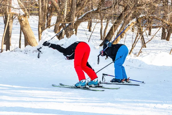 Samara, Russia - February 10, 2018: Young women in sport gear learns to ride skiing in sunny winter day