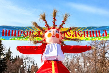 Samara, Russia - March 6, 2017: Shrovetide in Russia. Big doll for the burning. Maslenitsa or Pancake Week is the Slavic Holiday. Text in russian: Wide Shrovetide clipart