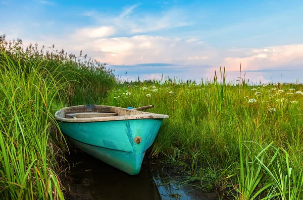 Stará plastová rybářské lodi na břehu řeky — Stock fotografie