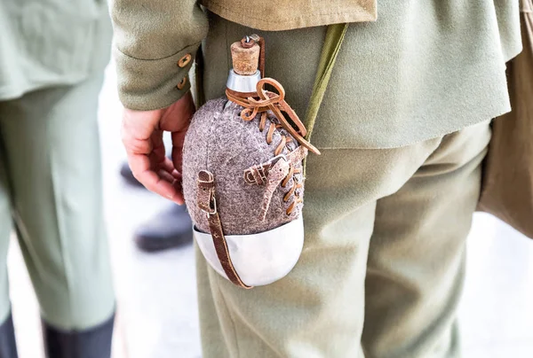 Vintage military flask hangs on a belt from a soldier — Stock Photo, Image