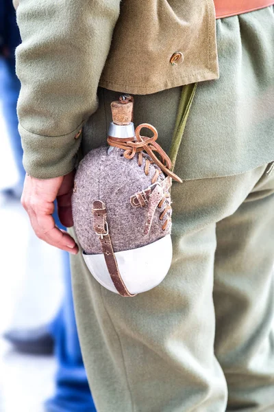 Vintage military flask hangs on a belt from a soldier — Stock Photo, Image