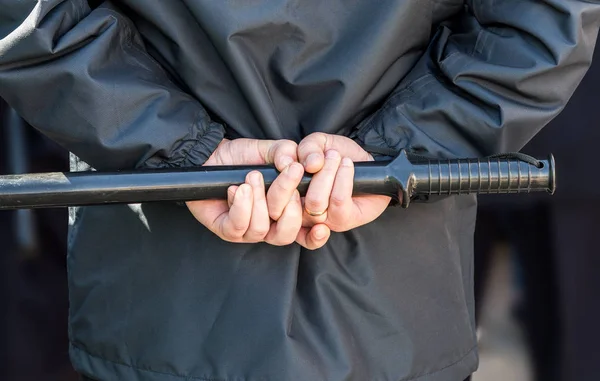 Rendőrségi gumibot a rendőr kezében — Stock Fotó