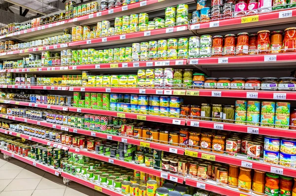 Ingeblikte groenten en fruit in blikjes in de schappen — Stockfoto