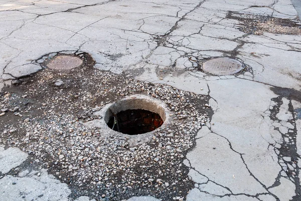 아스팔트 도로에 안전하지 않은 하수 맨홀 을 엽니 다 — 스톡 사진