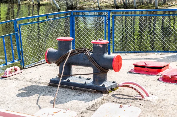 Amarre bolardo de metal con un halcón en el muelle —  Fotos de Stock