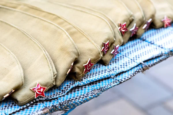 Στρατιωτικά καπέλα με κόκκινα αστέρια, στρατιωτική στολή — Φωτογραφία Αρχείου