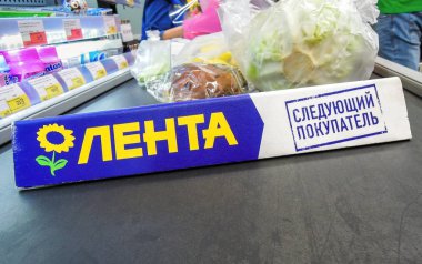 Hipermarketteki konveyör bandı üzerinde mal ayırıcı Lenta. Metin 