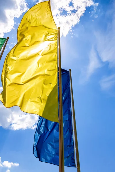 Kleurrijke vlaggen in de wind tegen de blauwe lucht — Stockfoto