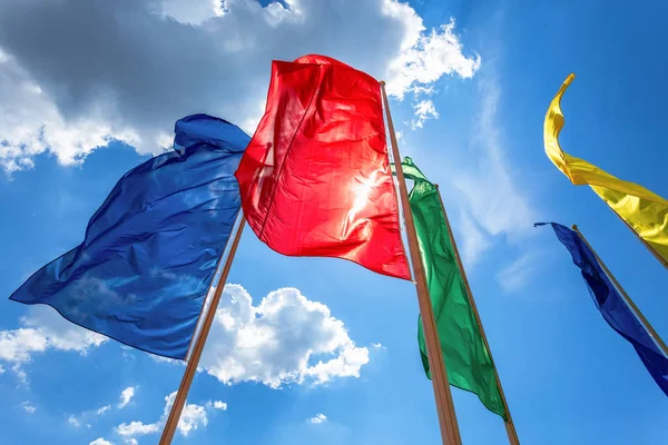 Bendera berwarna dalam angin melawan langit biru — Stok Foto