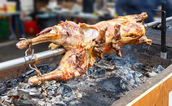 Cottura agnello carcassa su uno spiedo su carboni ardenti — Foto Stock