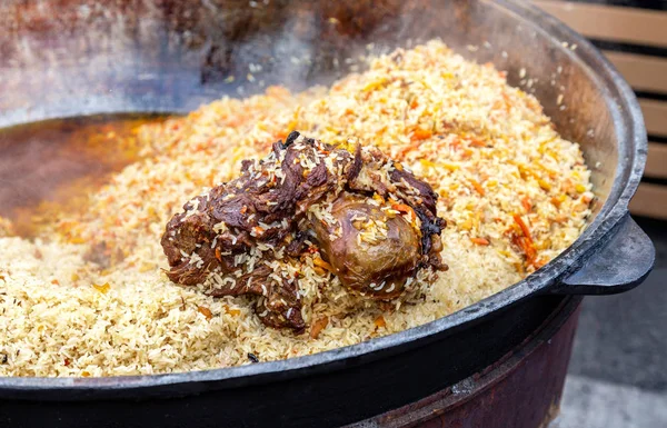 Traditionelle usbekische Pilaf in einem großen Kessel — Stockfoto