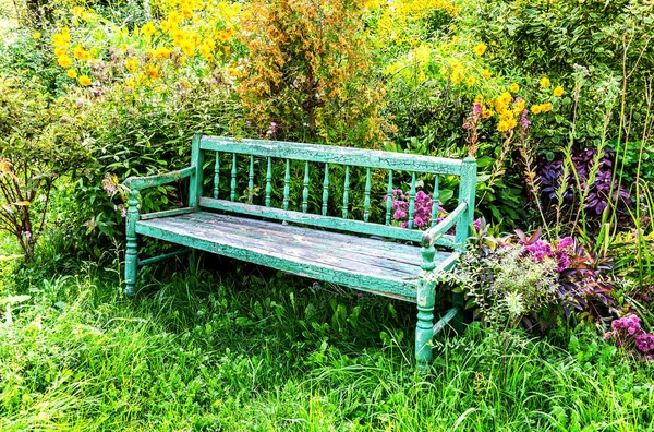 Antiguo banco de madera en el jardín de flores — Foto de Stock