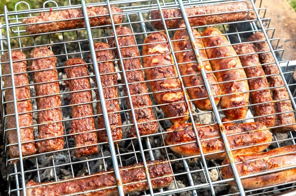 Enchidos deliciosos de carne em uma grade metálica — Fotografia de Stock