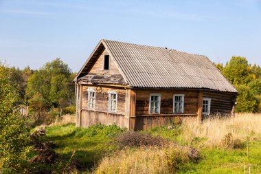 Yazın kırsal kesimde terk edilmiş eski ahşap bir ev. Novgorod bölgesi, Rusya