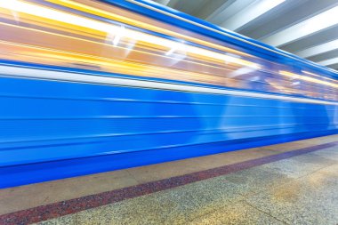 Mavi metro treni yeraltı istasyonunda hareket halinde.