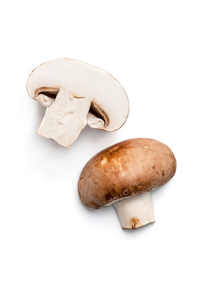 Two halves of a champignon with a brown cap. Isolated on white background