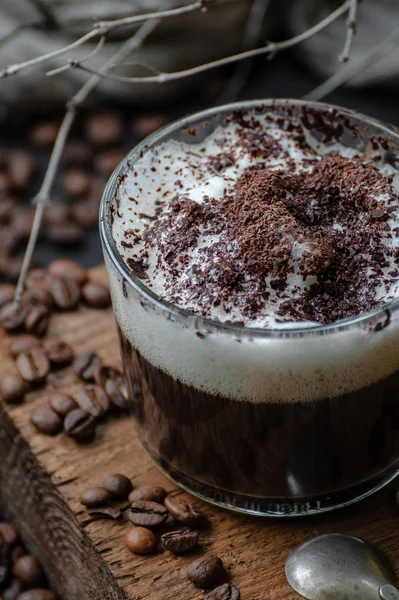 Cappuccino kahve süt köpüğü ve ahşap pano portre çikolata ile. Düşük anahtar fotoğraf.