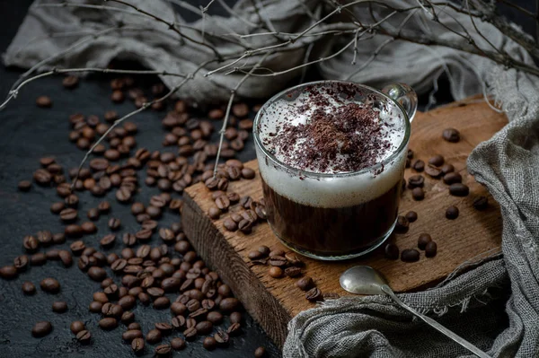 Cappuccino kahve süt köpüğü ve çikolata ek aksesuarlar ile ahşap bir gemide. Yatay olarak yönlendirilmiş çerçeve.