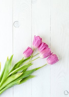 Beyaz ahşap masa üzerinde pembe laleler. 