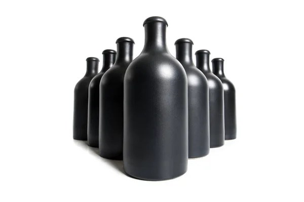 Botellas negras mate sobre fondo blanco de cerca Fotos de stock libres de derechos