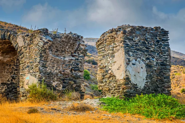 Eine antike Mauer mit einem Steinbogen, der in den Bergen gebaut wurde. — Stockfoto