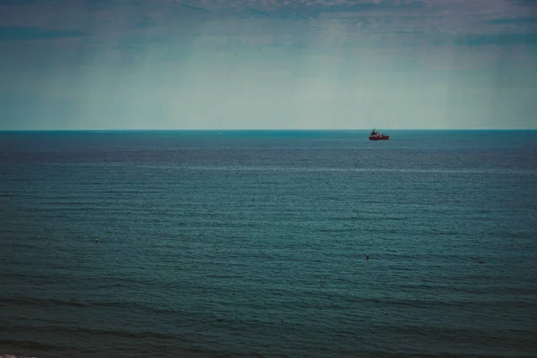 Buque de contenedores fondeado en el horizonte — Foto de Stock