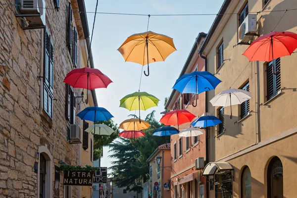 Novigrad, Kroatien-8 augusti 2016: gata med mångfärgade paraplyer — Stockfoto