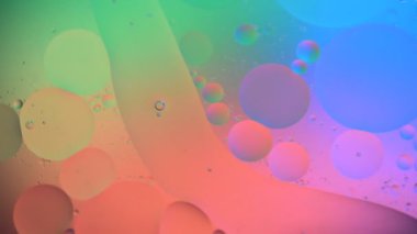 Yağ damlaları suda hareket ediyor. Renkli degrade renklerle soyut arka plan. Makro çekimi. Dof