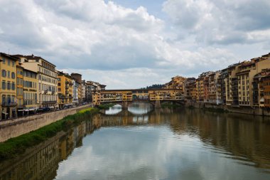 FLORNCE, ITALY - 24 NİSAN 2019: Ponte Vecchio. Floransa 'daki tarihi binaların manzarası. Nehirdeki yansıma