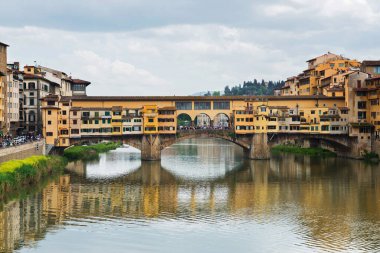 FLORNCE, ITALY - 24 NİSAN 2019: Ponte Vecchio. Floransa 'daki tarihi binaların manzarası. Nehirdeki yansıma