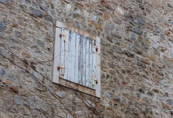 Ventana de madera cerrada en el día. Muralla en la ciudad vieja, Budva, M — Foto de Stock