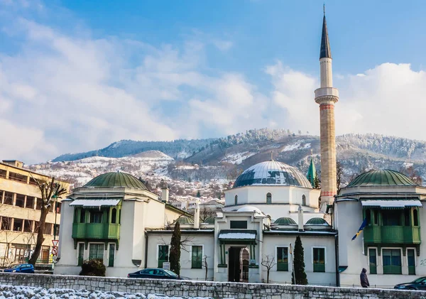 Ein Minarett erhebt sich über Gebäuden auf der anderen Flussseite des Altstadtviertels von Sarajevo, Bosnien-Herzegowina — Stockfoto