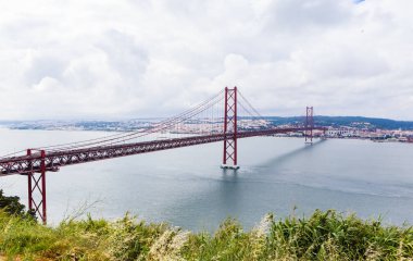 Ponte 25 de Abril Bridge in Lisbon, Portugal. Connects the cities of Lisbon and Almada crossing the Tagus River. View from Almada with Lisbon across