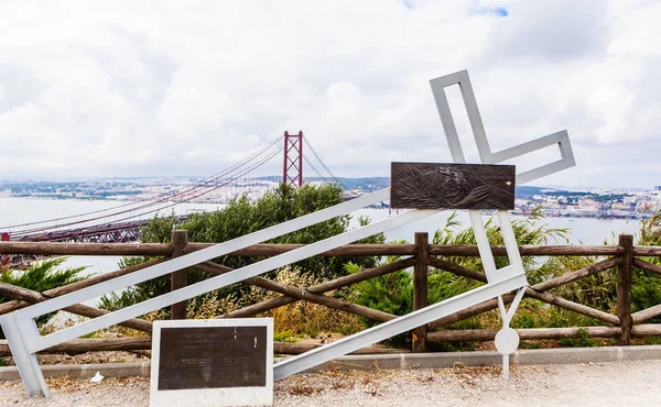 Installation med en fallen metall korsning nära Kristus kungen staty i Lissabon, Portugal — Stockfoto