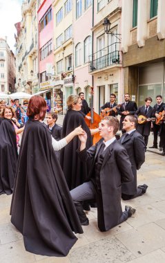 Bir grup öğrenci müzisyen ve turistlerle skeç oynuyor.