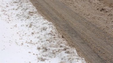 Su birikintileri ve kar ile kirli kış yolu.