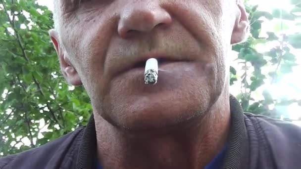 L'uomo fuma sigarette e rilascia fumo dalla bocca — Video Stock