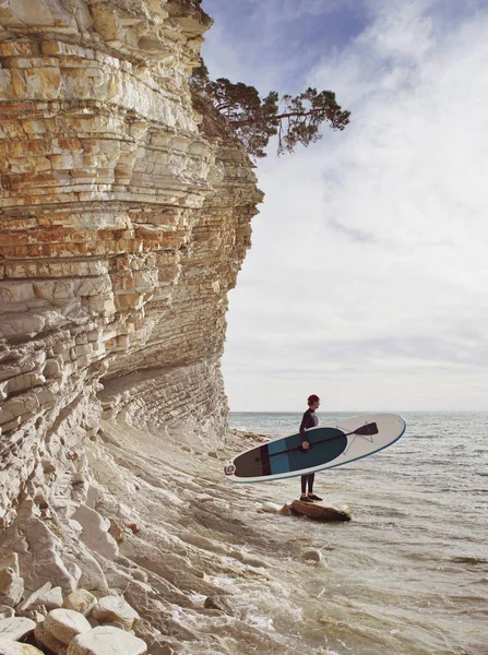 Jovem com SUP bordo de pé na praia — Fotografia de Stock